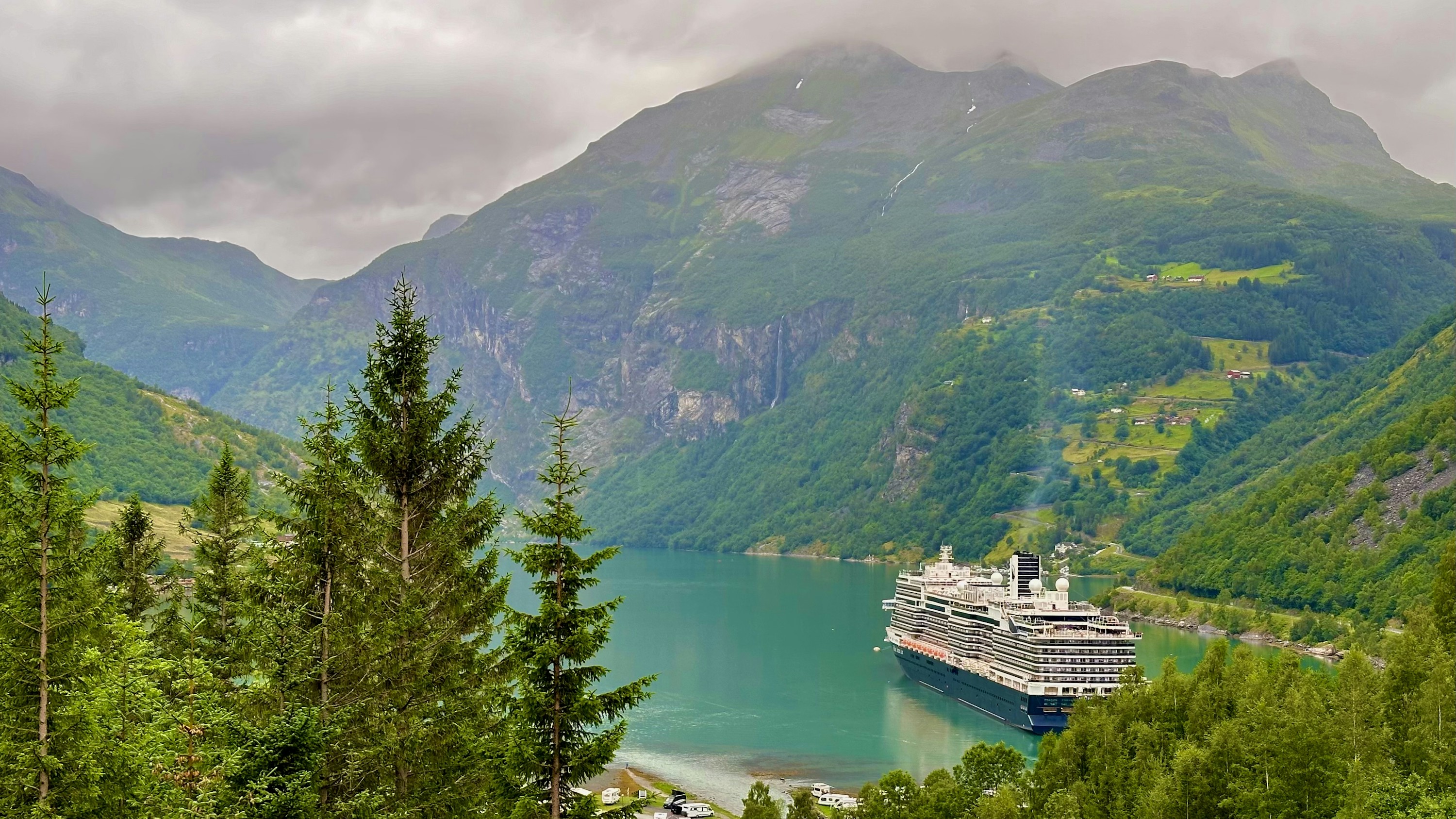 Navă de croazieră în fiordul Geiranger, înconjurată de munți norvegieni